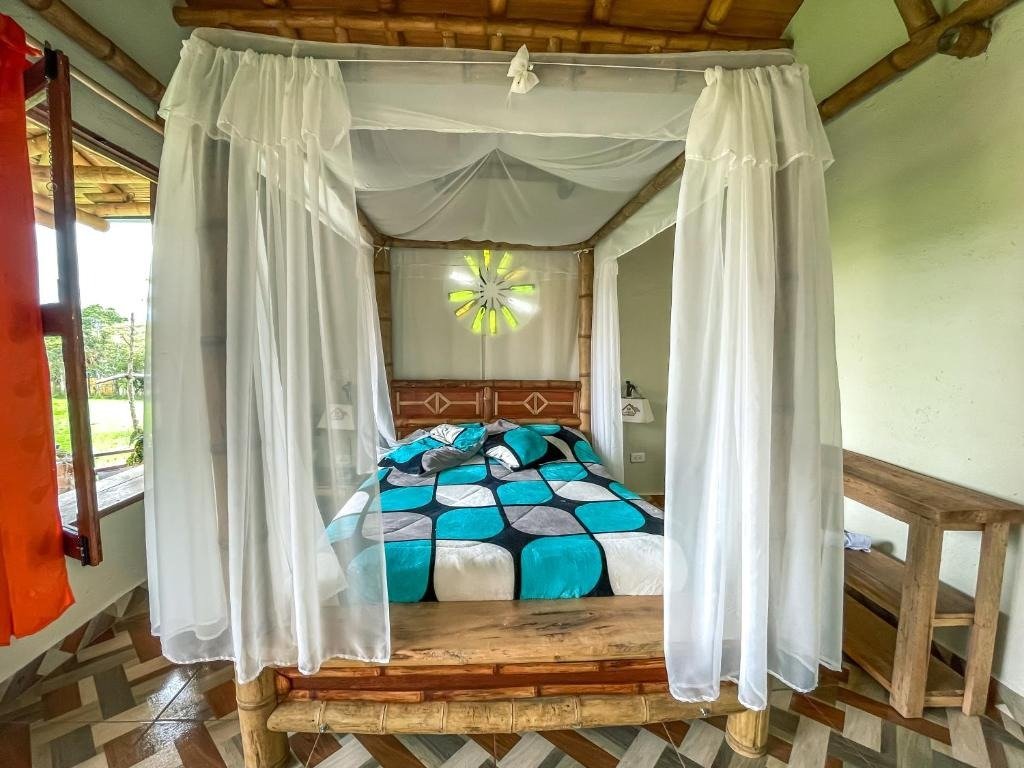 Habitación con cama matrimonial y dosel protector artesanal