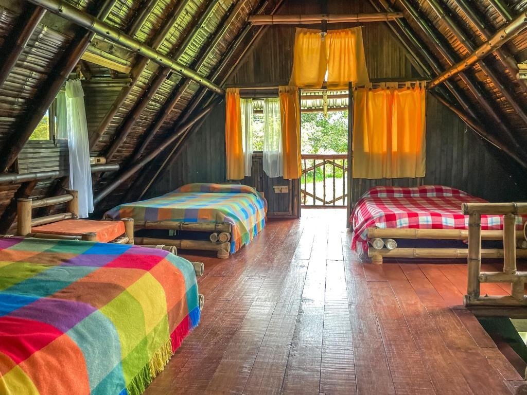 Dormitorio múltiple en altillo con camas individuales y vigas inclinadas de madera