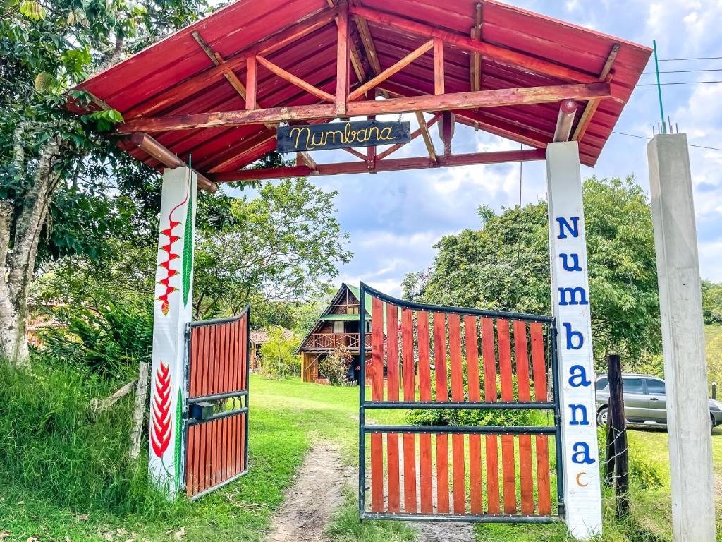 Portada de entrada rústica en madera hacia el hospedaje
